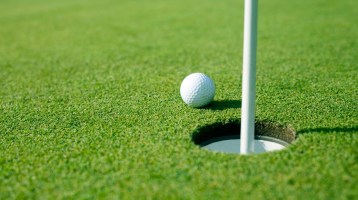 golf ball next to hole